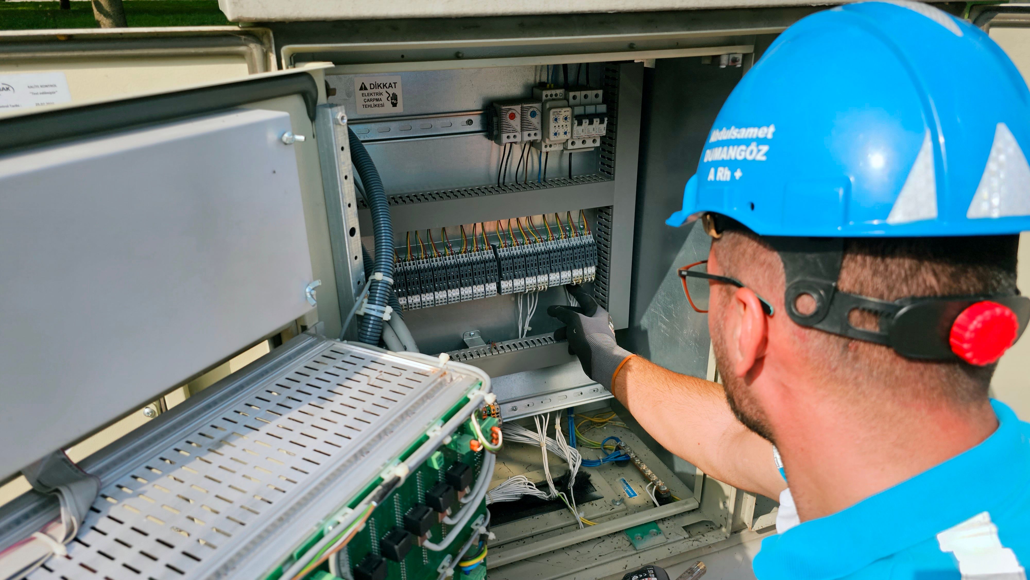 Electrician working on an outdoor electrical panel