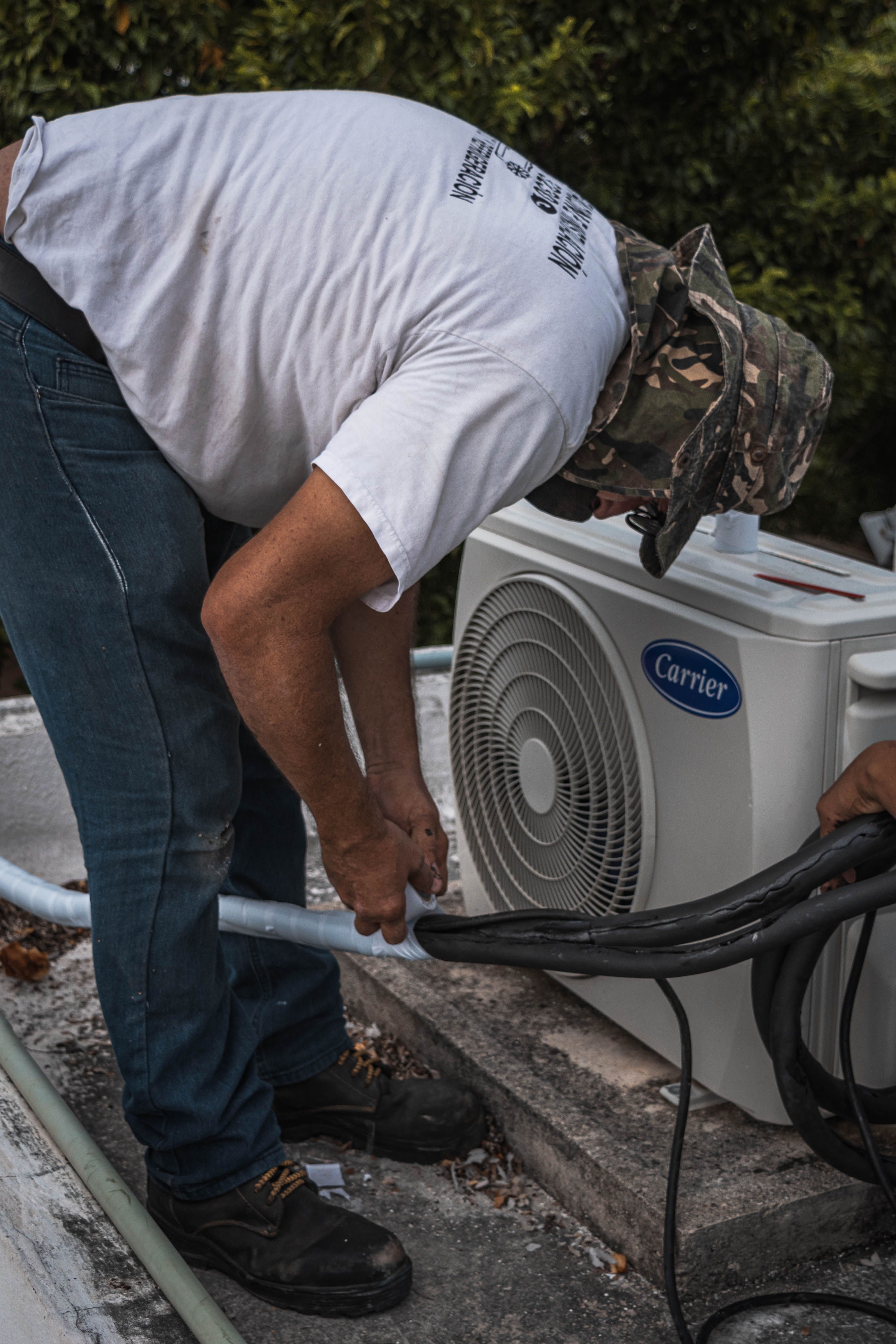 HVAC technician performing maintenance on an outdoor air conditioning unit