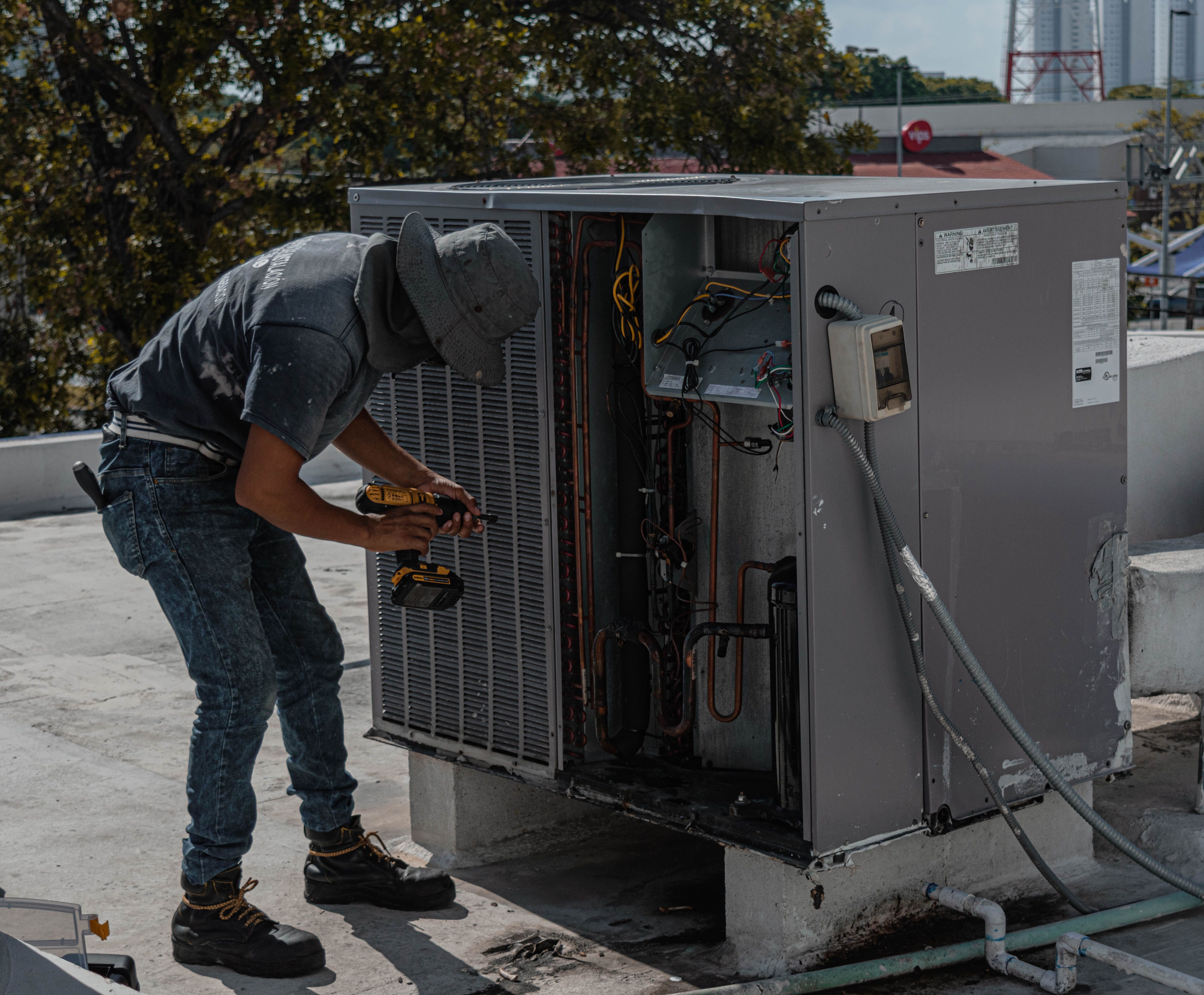 HVAC technician repairing an outdoor air conditioning unit